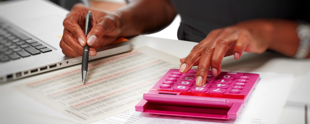 Hands of afro american accountant woman working with calculator.